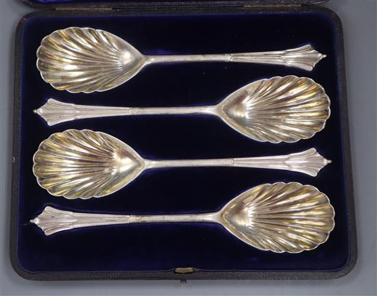 A cased set of four Victorian silver serving spoons, London, 1895 and a cased set of twelve pairs of silver dessert eaters.